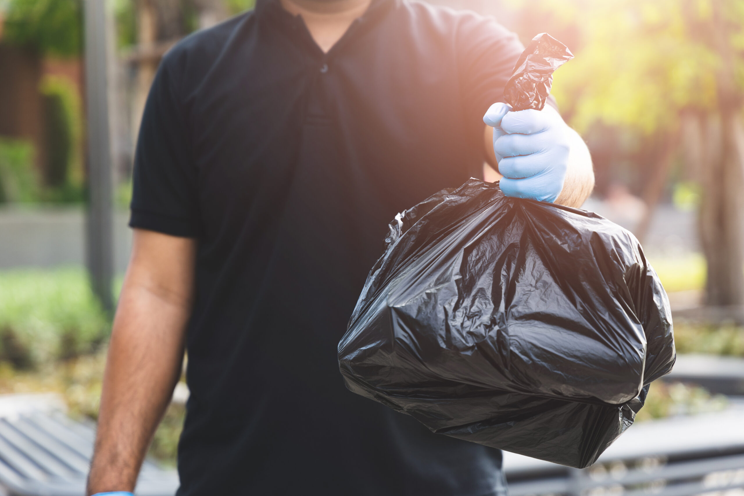 The young man separated the dangerous waste into a large black bag and put it in the trash. The correct sorting of waste Household waste